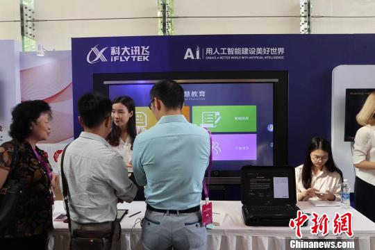 参观者在向工作人员了解科技产品。 王坚 摄 参观者在向工作人员了解科技产品。 王坚 摄