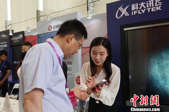 参观者在向工作人员了解科技产品。 王坚 摄 参观者在向工作人员了解科技产品。 王坚 摄