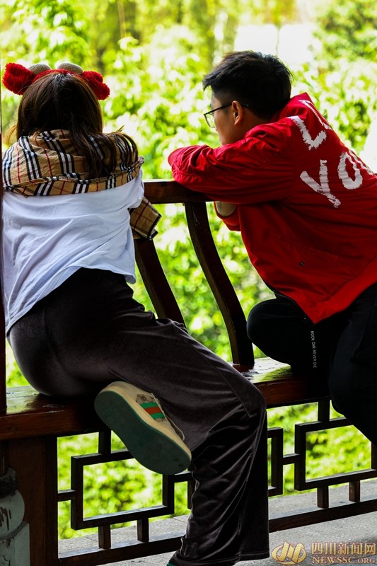 摄于铁像寺水街万福桥亭内 两位年轻人倚靠亭柱观景.jpg